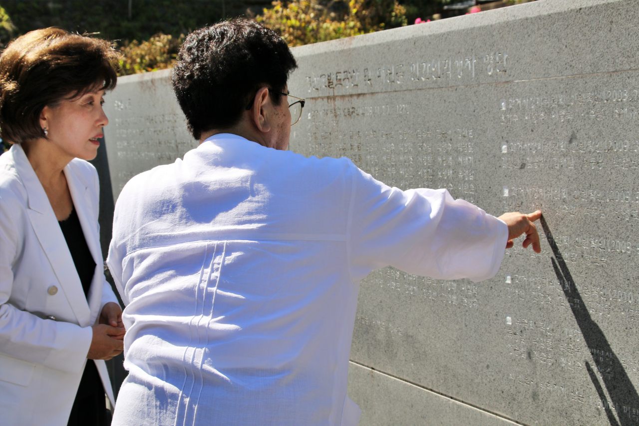 박선영 2기 진실화해위원장이 민간인학살 현장인 경북 경산시 코발트광산을 찾았다. 나정태 유족회장이 위령탑에 적힌 희생자들의 이름을 손가락으로 가리키고 있다.(2025.7.25) / 사진.평화뉴스 김영화 기자 