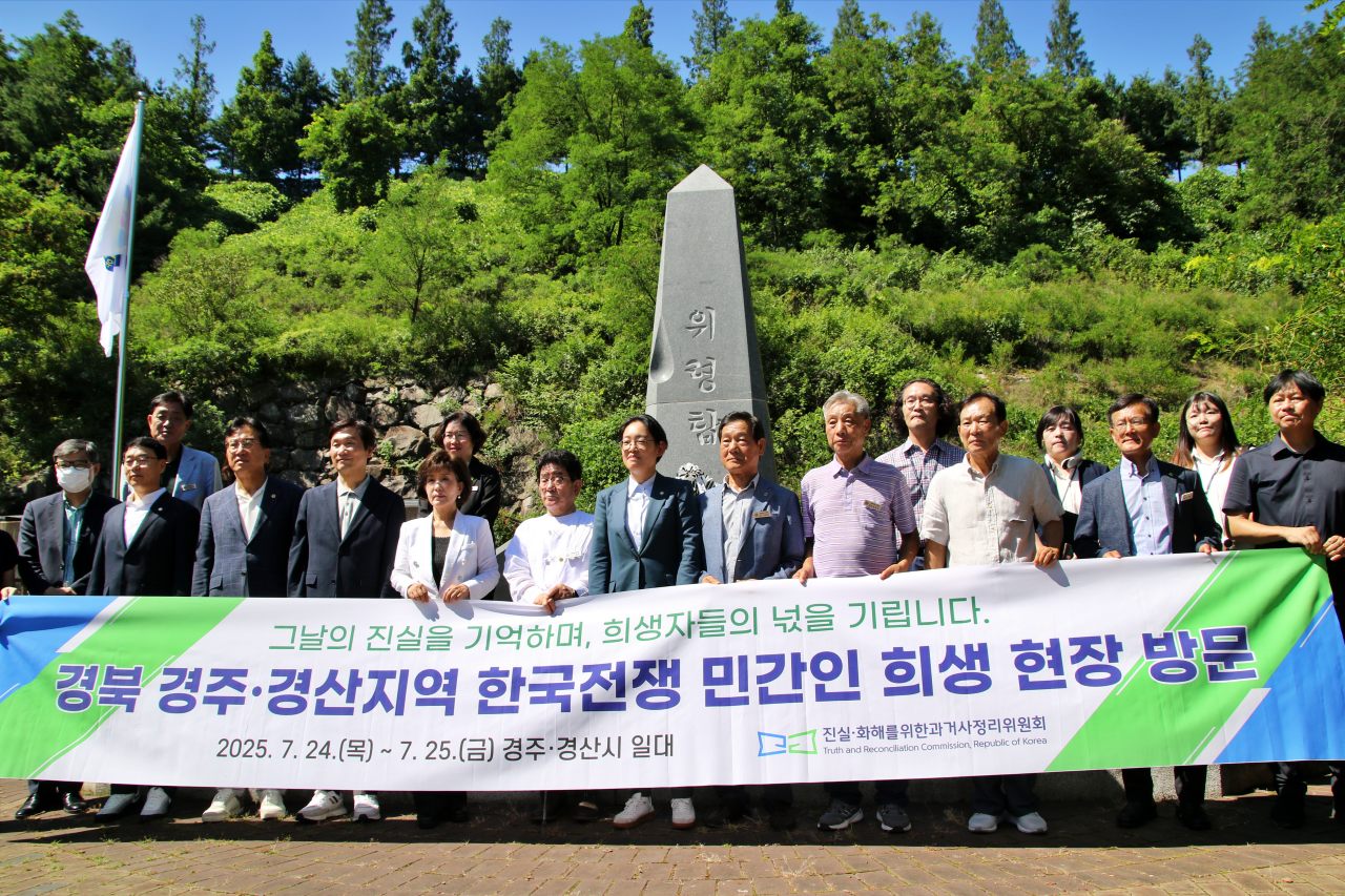 (왼쪽에서 네버째부터)조현일 경산시장, 박선영 진화위원장, 나정태 유족회장, 조지연 국회의원 등 유족과 진화위와 경산시 관계자들이 코발트광산 위령탑 앞에서 사진을 찍고 있다.(2025.7.25) / 사진.평화뉴스 김영화 기자 