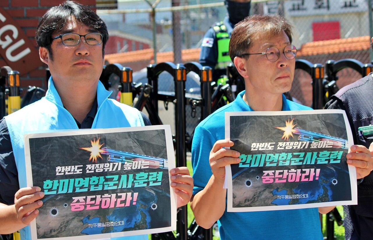 (왼쪽부터) 이승민 진보당 대구시당 자주평화통일위원장과 이대동 사무처장이 "한반도 전쟁 위기 높이는 한미연합군사훈련 중단하라"고 적힌 피켓을 들고 있다.(2025.7.25) / 사진.평화뉴스 정준민 기자