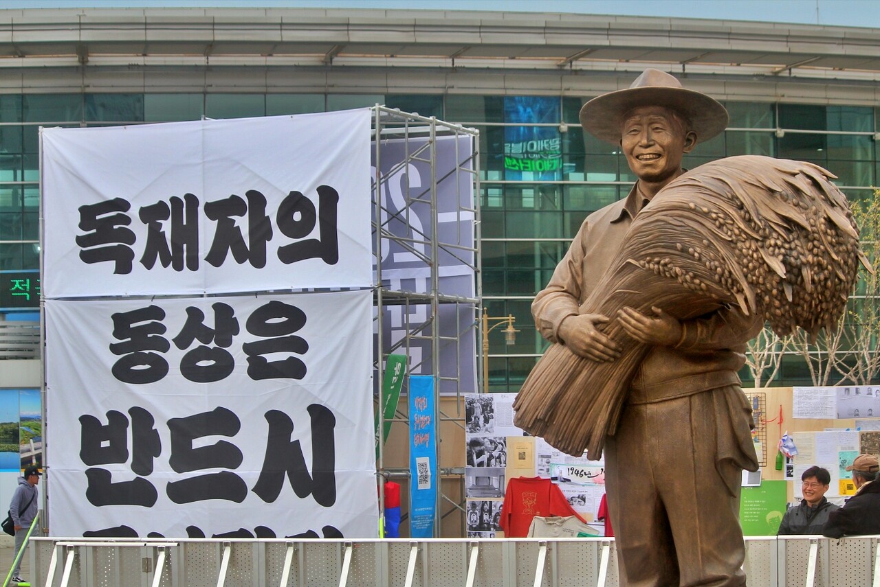 동대구역에 세워진 박정희 동상 뒤편으로 "독재자의 동상은 반드시 무너진다"고 적힌 현수막이 걸려 있다.(2025.4.5) / 사진.평화뉴스 정준민 기자