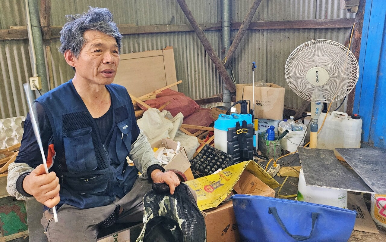 남산(가명)씨가 농사일을 하고 창고에 들어와 선풍기를 틀고, 부채를 부치고 있다.(2025.8.22) / 사진.평화뉴스 정준민 기자