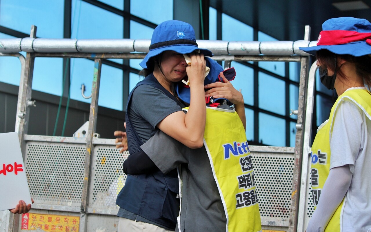 박정혜 금속노조 한국옵티칼하이테크지회 수석부지회장이 공장 옥상에서 내려온 뒤 조합원들을 껴안으며 눈물을 흘리고 있다.(2025.8.29) / 사진.평화뉴스 정준민 기자