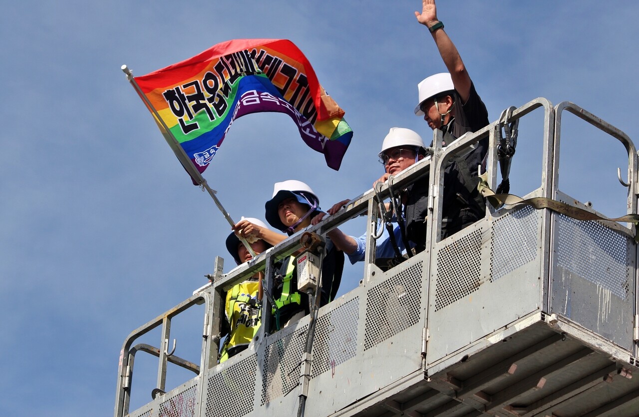 박정혜 수석부지회장이 공장 옥상에서 크레인을 타고 내려오며 노조 깃발을 흔들고 있다.(2025.8.29) / 사진.평화뉴스 정준민 기자