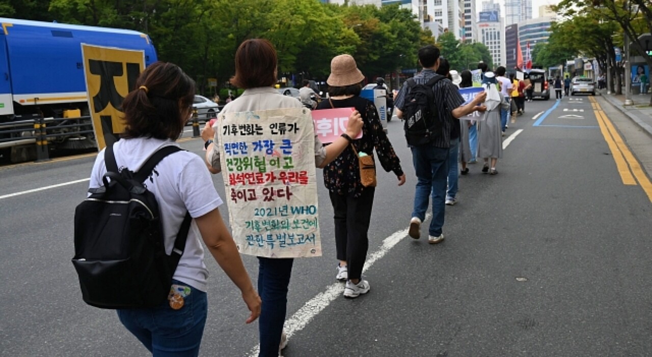 "기후변화는 인류가 직면한 가장 큰 건강위협"이라고 적힌 현수막을 등에 붙이고 행진하는 모습(2023.9.20) / 사진.평화뉴스 정준민 기자