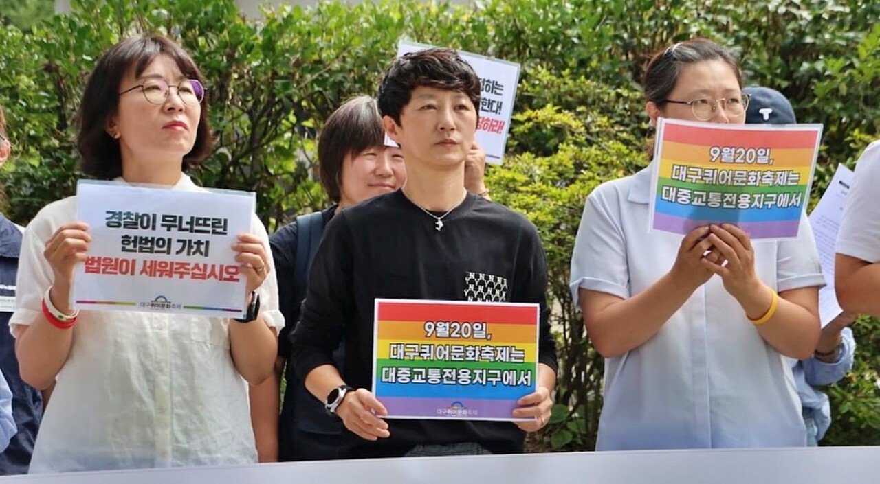 "경찰이 무너뜨린 헌법의 가치, 법원이 세워주십시오", "9월 20일 대구퀴어문화축제는 대중교통전용지구에서" 피켓을 들고 있는 모습(2025.9.15.대구지방법원 앞) / 사진 출처.대구퀴어문화축제 조직위원회