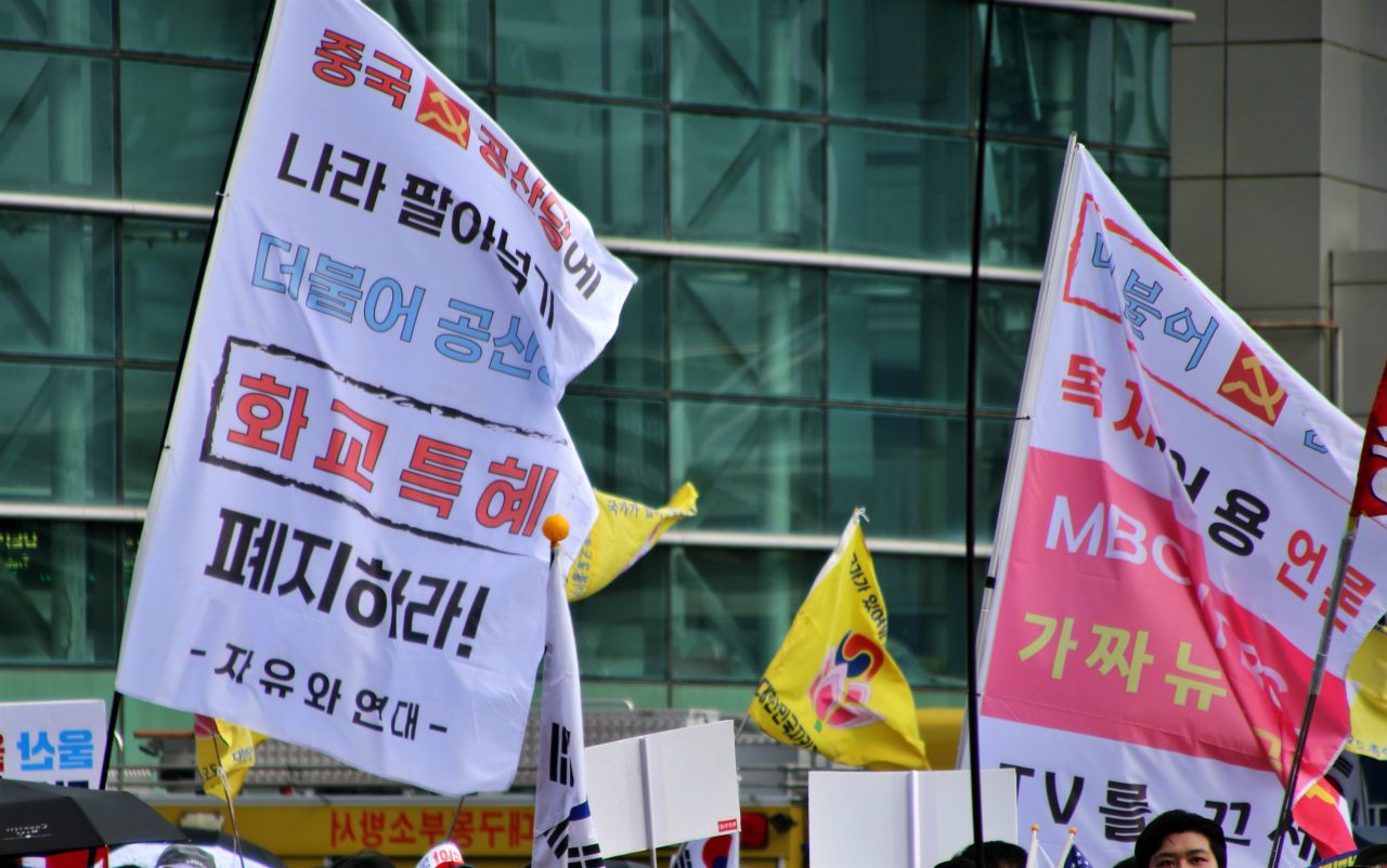 "중국 공산당에 나라 팔아넘긴 더불어 공산당, 화교 특혜 폐지", "MBC, JTBC 독재 어용 언론" 혐중 음모론이 적힌 깃발이 집회 현장에 휘날리고 있다.(2025.9.21) / 사진.평화뉴스 김영화 기자