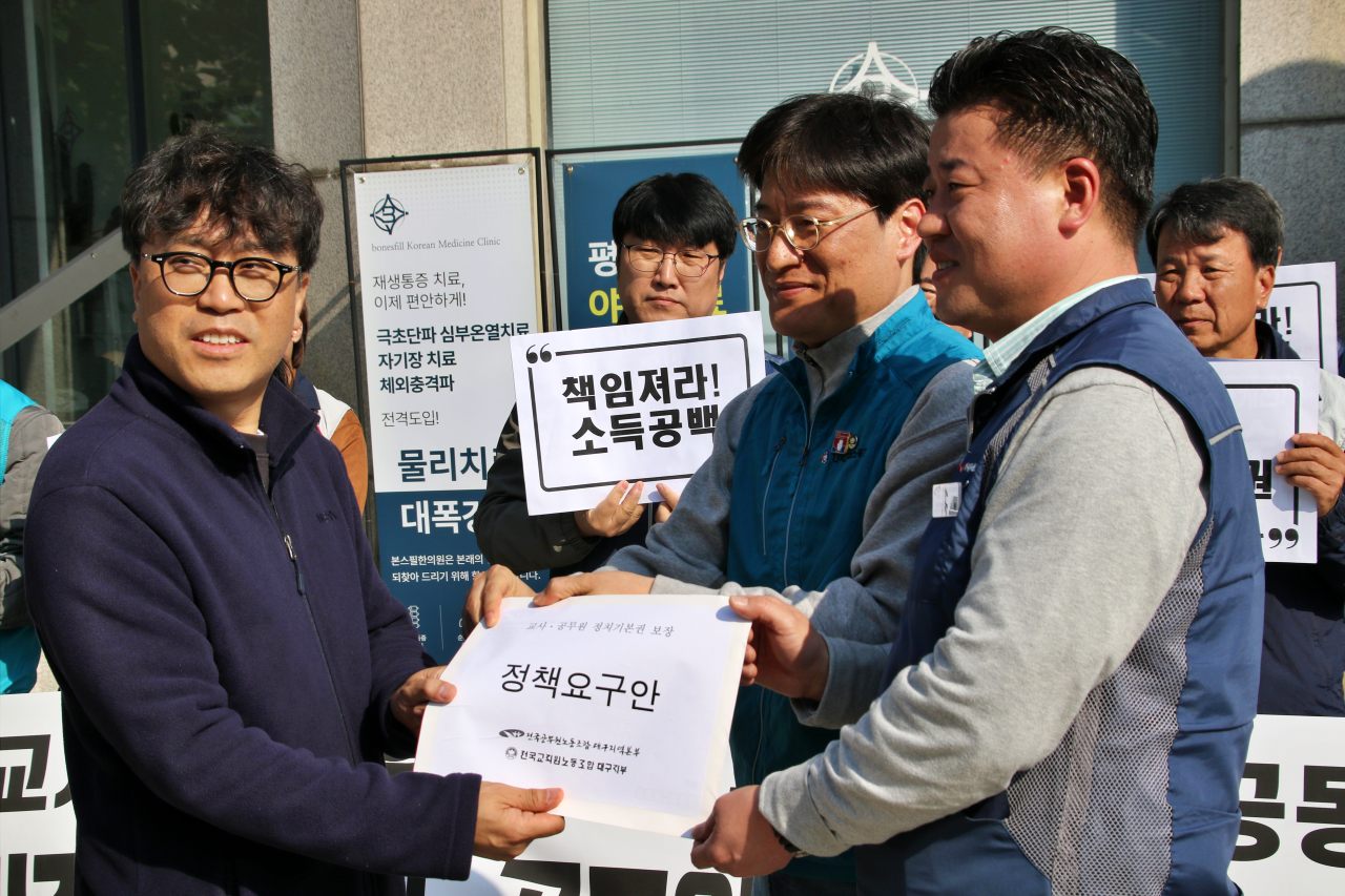 (왼쪽부터)이창호 민주당 대구시당 조직국장에게 '교사와 공무원의 정치기본권 보장' 내용을 담은 정책요구안을 전달하는 김도형 전교조 대구지부장과 김규환 전공노 대구본부장(2025.11.5) / 사진.평화뉴스 김영화 기자  