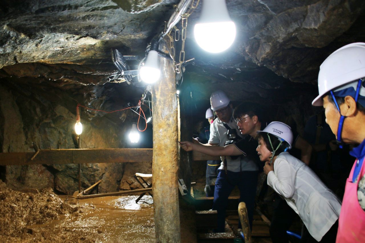 경북 경산시 코발트광산 수평갱도 안으로 들어온 박선영 진화위원장이 민간인 학살 유해발굴 현장에서 설명을 듣고 있다.(2025.7.25)  / 사진.평화뉴스 김영화 기자